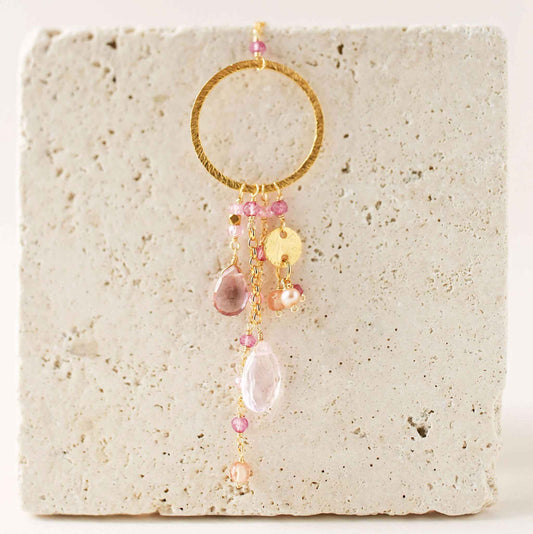 The Ammil Necklace featuring rose pink quartz and tourmaline gemstones with gold hoop and pink gemstone strands