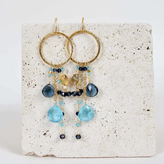 Iolite & Aquamarine Ammil EarringsMultiple strands of lush gems sparkle on a 1" hoop.
- Aquamarine Quartz and Iolite gemstones- 3.5" long- French hooks- 14k gold plated .925 fine Italian sterling silEarringsPARKEN JEWELRYVettedArcIolite & Aquamarine Ammil Earrings