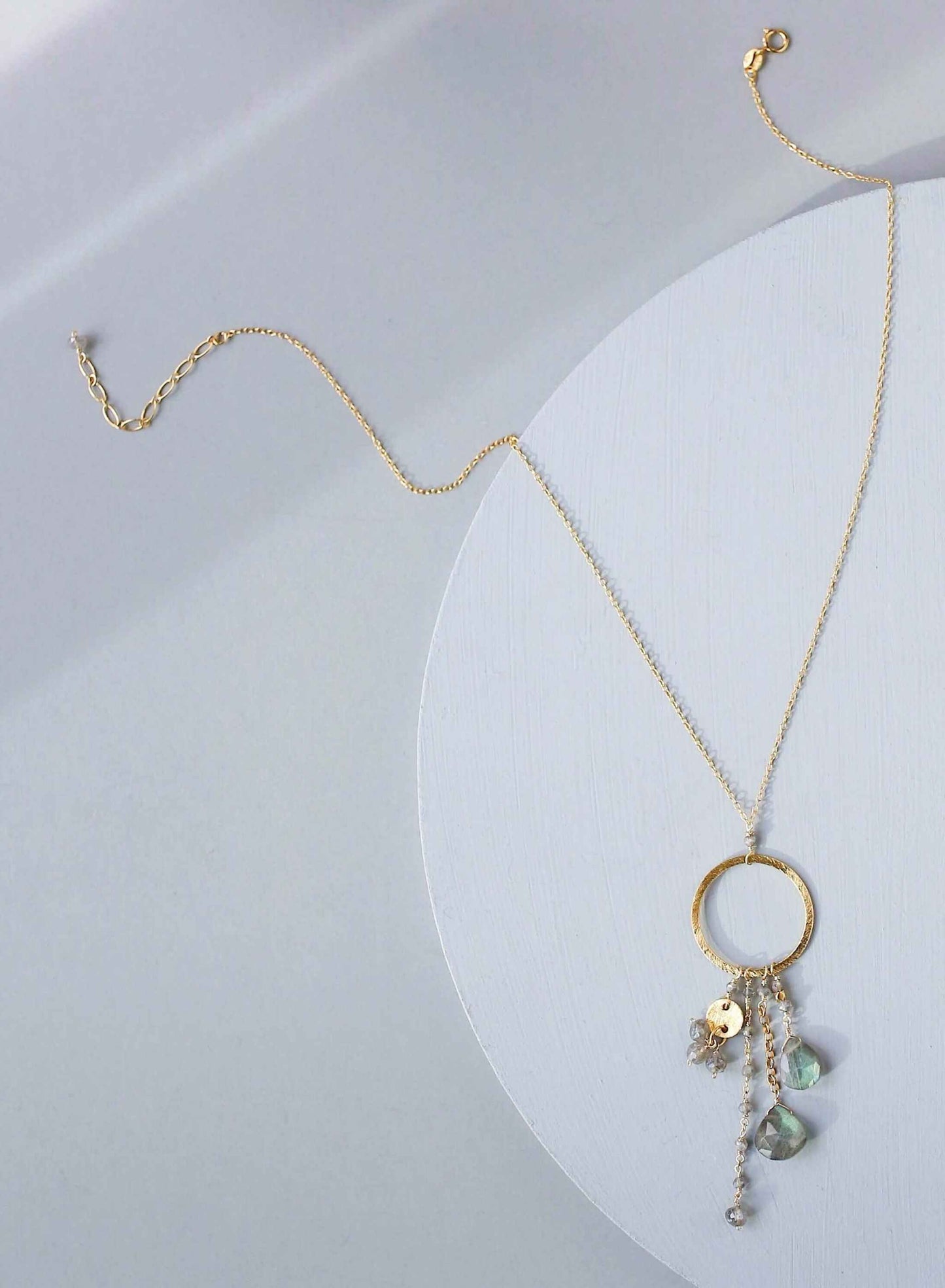 The Ammil Necklace featuring a lush labradorite gemstone pendant with multiple gemstone strands on a 14k gold plated hoop, handmade in New York City.