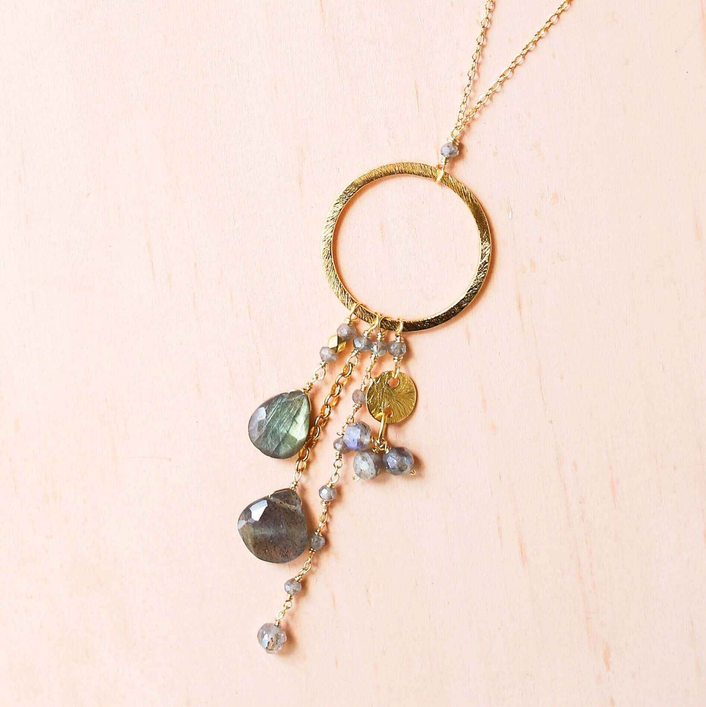 The Ammil Necklace featuring a labradorite pendant with multiple gemstone strands on a 14k gold plated sterling silver hoop.