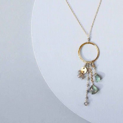 The Ammil Necklace featuring a labradorite gemstone pendant with multi-strand gemstone details on a 14k gold plated hoop.
