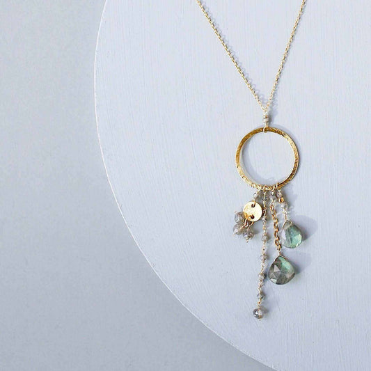 The Ammil Necklace featuring a labradorite gemstone pendant with multi-strand gemstone details on a 14k gold plated hoop.