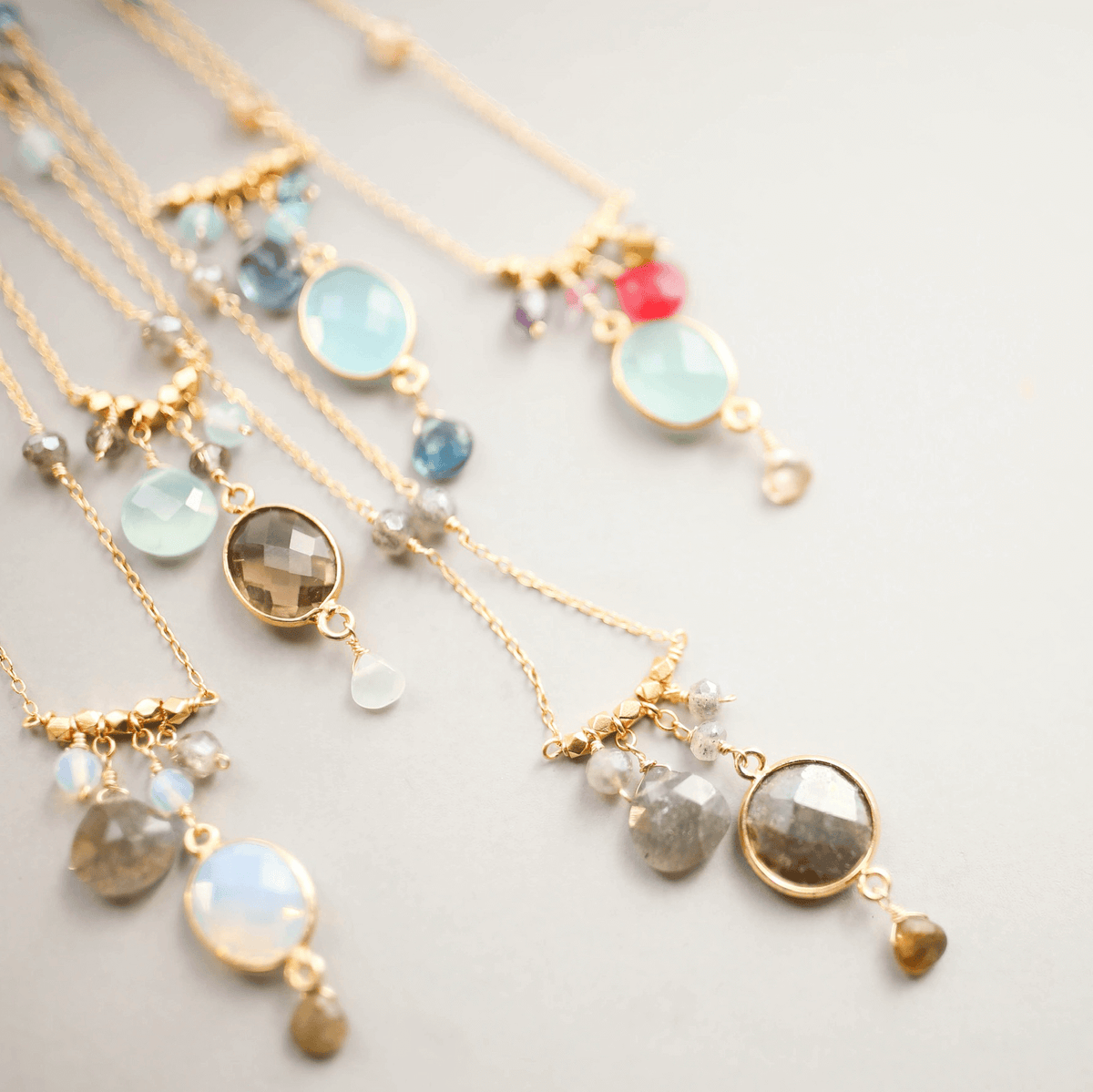 Elegantly crafted bezel necklaces with various bezel set gemstones on delicate gold chains