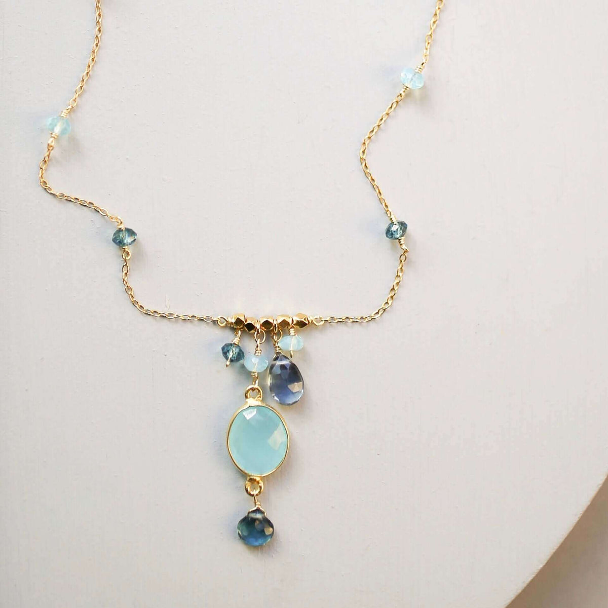 Delicate bezel necklaces with various bezel set gemstones on gold chains.