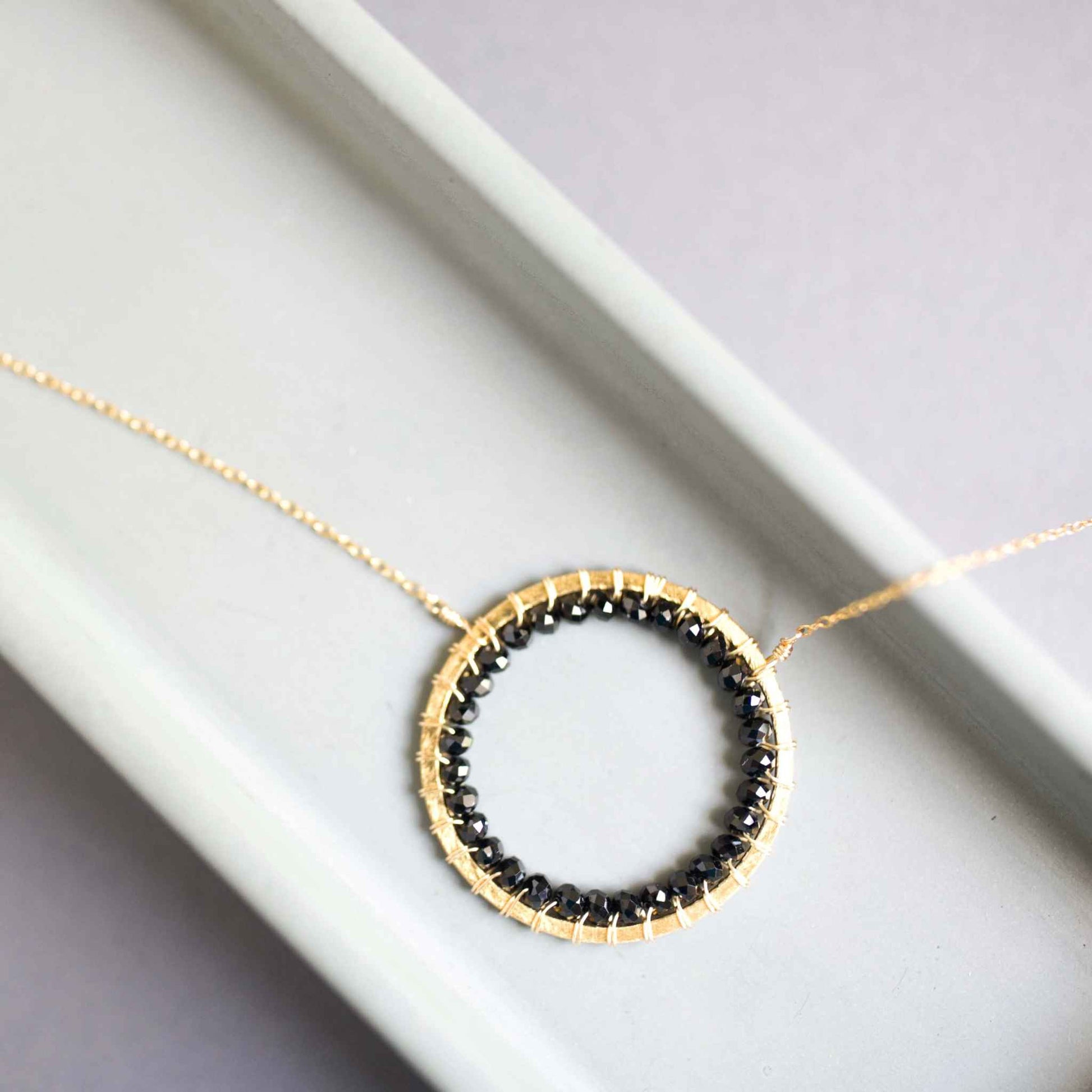 Black Spinel Halo Necklace with 14k gold plated sterling silver chain and floating pendant design