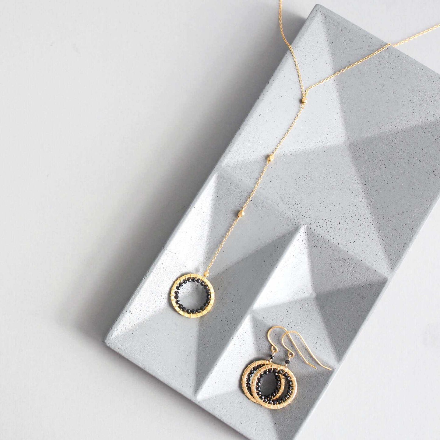 Black spinel pendant with rainbow gemstones and pearl on gold plated chain
