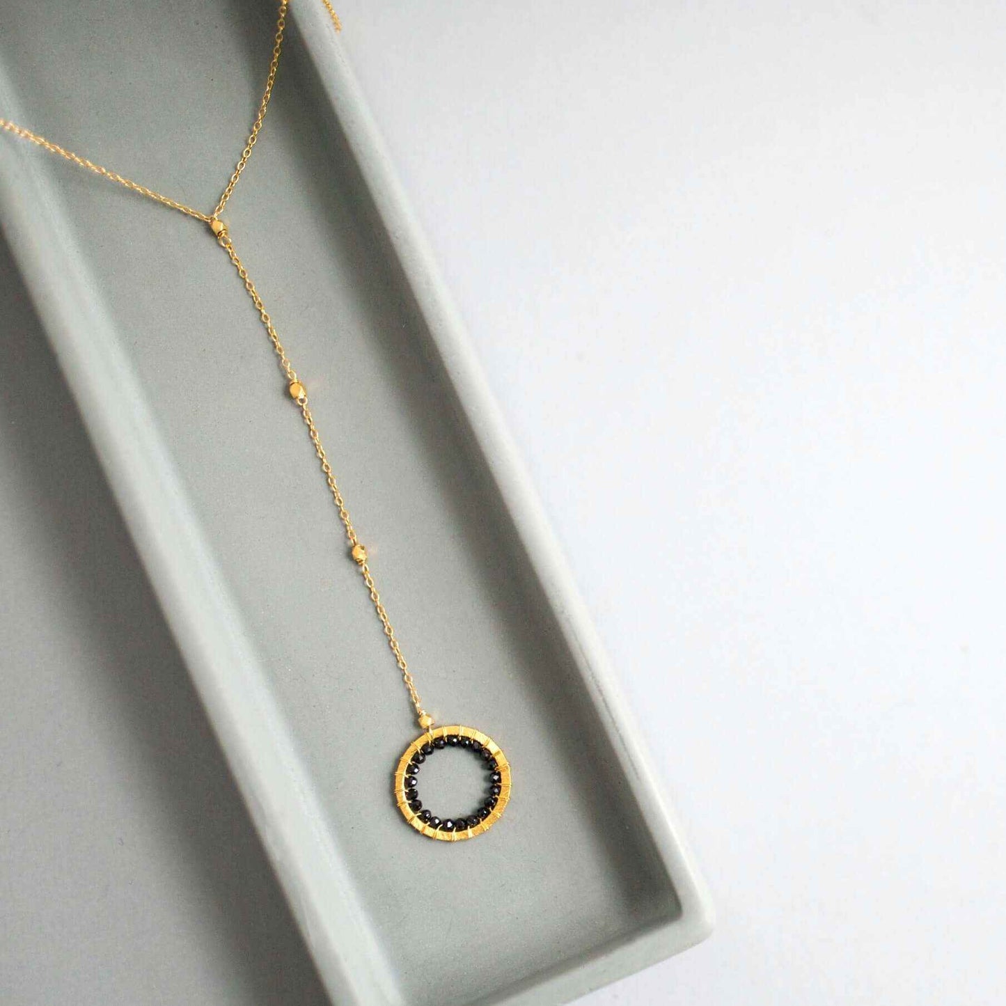 Black Spinel pendant with rainbow gemstones and pearl on a 14k gold plated Y necklace
