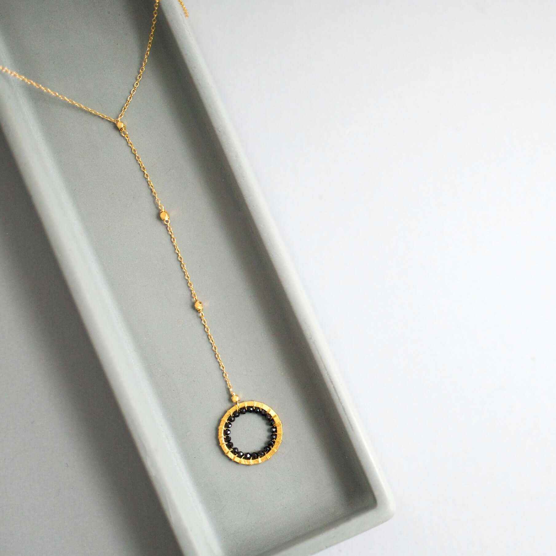 Black Spinel pendant with rainbow gemstones and pearl on a 14k gold plated Y necklace