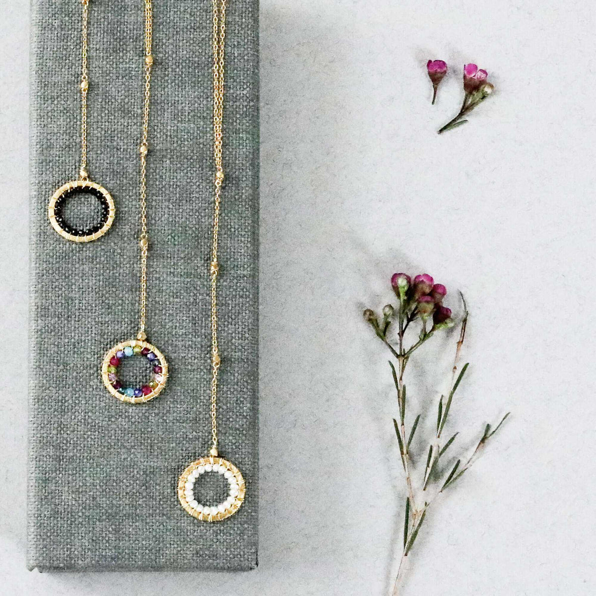 Black Spinel pendant with rainbow gemstones and pearl on gold-plated silver chain in Y-shaped halo design
