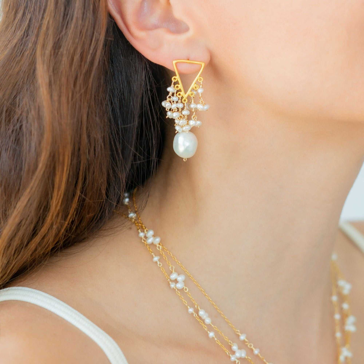 Close-up of 14k gold plated freshwater pearl fringe earrings with post backs on display