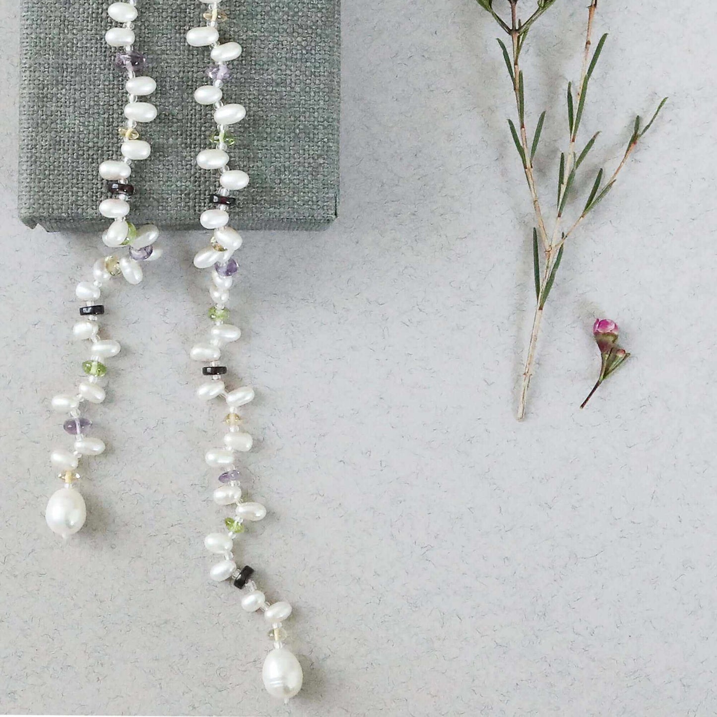Pearl and gemstone ballet lariat necklace with freshwater pearls and multicolored gemstones on white background