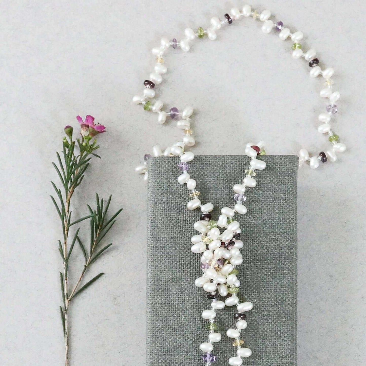 Pearl and gemstone ballet lariat necklace with freshwater pearls and multicolored gemstones displayed on white background