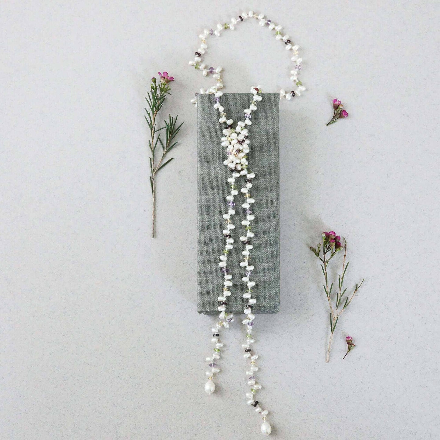 Pearl and gemstone ballet lariat necklace with freshwater pearls and multicolored gemstones on white background