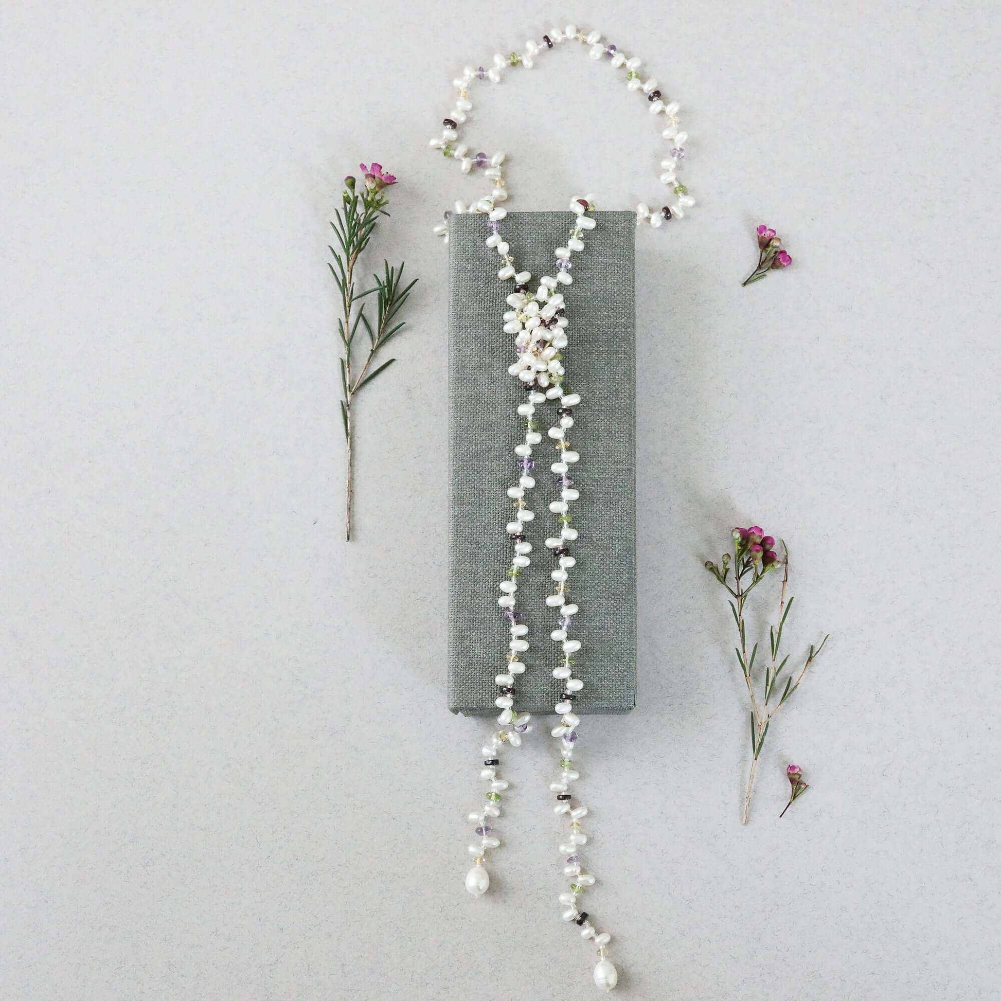 Pearl and gemstone ballet lariat necklace with freshwater pearls and multicolored gemstones on white background