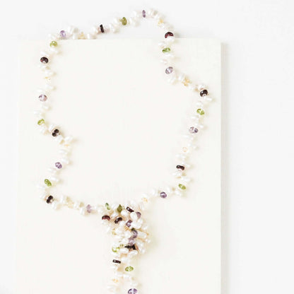 Pearl and gemstone ballet lariat necklace with freshwater pearls and multi-colored gemstones on a white background