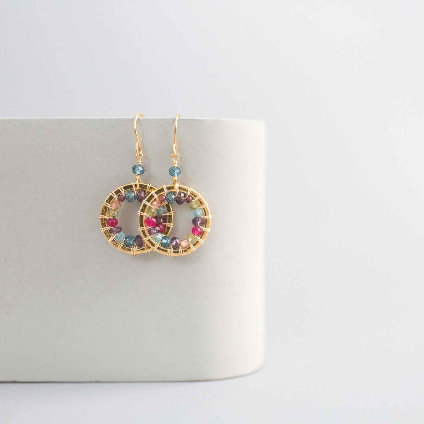 Close-up of Rainbow Halo Mini Earrings with multicolored gems and 14k gold plating on silver