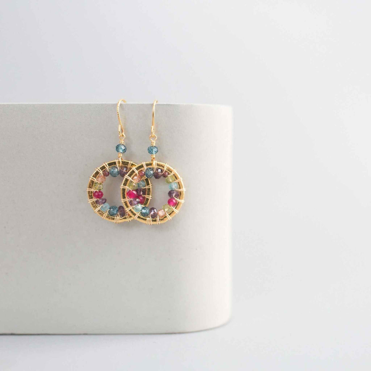 Close-up of Rainbow Halo Mini Earrings with multicolored gems and 14k gold plating on silver
