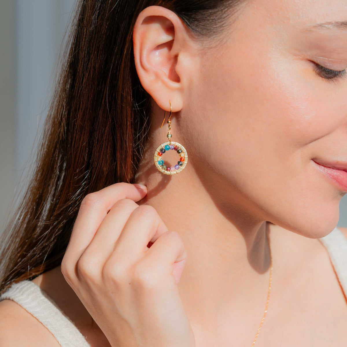 Close-up of Rainbow Halo Mini Earrings with sparkling rainbow gems and 14k gold plating on silver