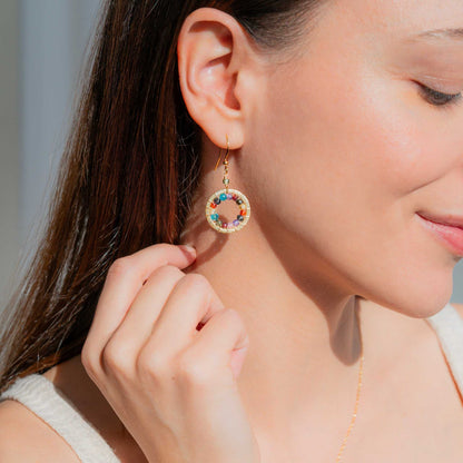 Close-up of Rainbow Halo Mini Earrings with sparkling rainbow gems and 14k gold plating on silver
