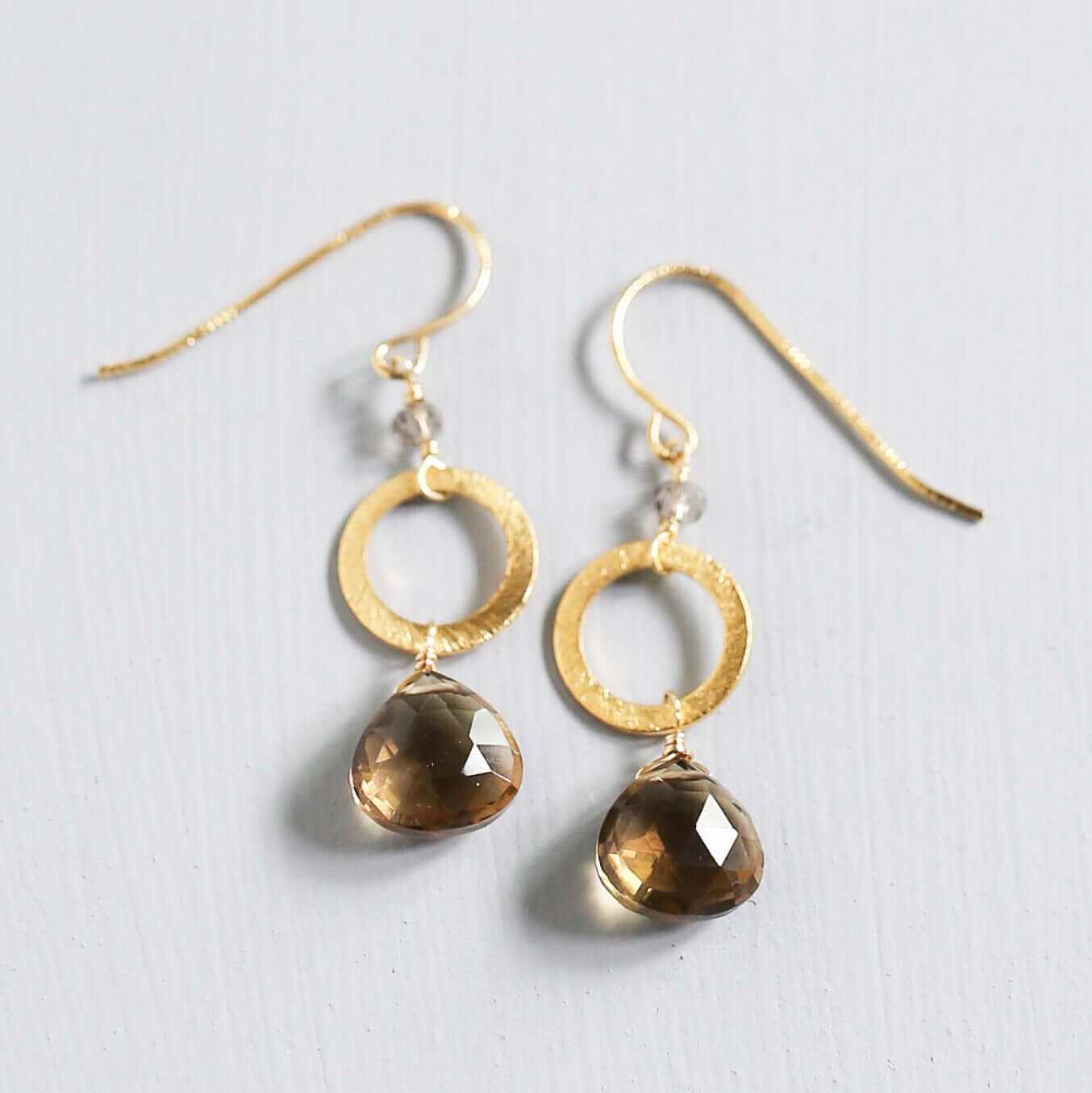 The Airie Earring smoky quartz gold 1.5-inch French hook earrings on a white background