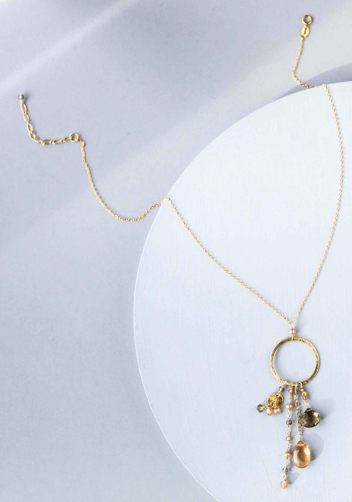 The Ammil Necklace featuring citrine and smoky quartz strands on a 14k gold plated sterling silver hoop
