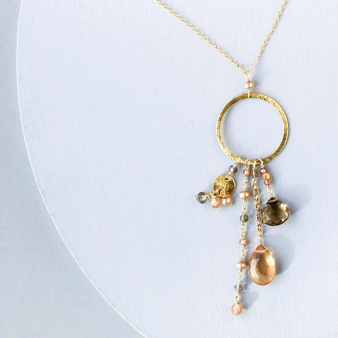 The Ammil Necklace featuring citrine and smoky quartz strands on gold hoop with 14k gold plated sterling silver and spring ring clasp